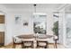 Sunlit dining room featuring an oval wood table, modern lighting, and backyard views at 1459 S Filbert Way, Denver, CO 80222