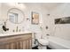 Stylish bathroom featuring a vessel sink, round mirror, and bathtub with white marble surround at 7452 W Cedar Cir, Lakewood, CO 80226