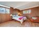 Bedroom with wood paneling, hardwood floors, natural light, and comfortable seating area at 1333 S Eudora St, Denver, CO 80222