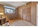 Bedroom featuring wood paneling, closet with wooden doors, wood floors, and bright natural light from a window at 1333 S Eudora St, Denver, CO 80222