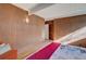 A cozy bedroom with wood paneling, hardwood floors, bright white ceiling, and a comfortable orange chair at 1333 S Eudora St, Denver, CO 80222