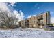 Tan multi-unit building with balconies and snowy yard at 1289 S Gilbert St # A302, Castle Rock, CO 80104