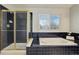 Primary bathroom featuring tub, shower, window and tiled walls with gold accents at 19058 E Hickock Dr, Parker, CO 80134