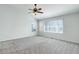 Bright bedroom offers neutral carpet, big windows and a ceiling fan with light at 19058 E Hickock Dr, Parker, CO 80134