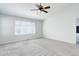 Bright bedroom offers neutral carpet, large window and ceiling fan with light at 19058 E Hickock Dr, Parker, CO 80134