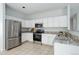 Bright kitchen features stainless steel appliances, white cabinets, granite counters, and tile backsplash at 19058 E Hickock Dr, Parker, CO 80134