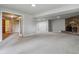 Spacious basement featuring gray walls, carpet, a brick fireplace, and access to a laundry room, perfect for entertaining at 2041 W Briarwood Ave, Littleton, CO 80120