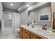 Bathroom featuring double sinks, neutral tile, and bathtub with shower at 2041 W Briarwood Ave, Littleton, CO 80120