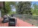 Relaxing outdoor deck featuring wood flooring, metal railings, and comfortable seating with pillows and views of greenery at 2041 W Briarwood Ave, Littleton, CO 80120