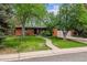 Charming brick home featuring a lush lawn, mature trees, and a welcoming walkway to the front door at 2041 W Briarwood Ave, Littleton, CO 80120