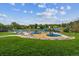 Community playground with slides and play structures, surrounded by grassy areas, trees, and blue canopies at 2041 W Briarwood Ave, Littleton, CO 80120