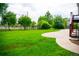 Expansive backyard with lush green grass, mature trees, and a stone patio at 7270 S Cherry Dr, Centennial, CO 80122