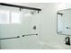 Modern bathroom featuring a glass-enclosed shower with white tile and black hardware at 7270 S Cherry Dr, Centennial, CO 80122