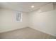 Clean, carpeted basement room with bright lighting, and simple window at 14890 W 58Th Pl, Golden, CO 80403