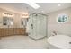 Bright bathroom featuring a glass shower, modern tub, quartz countertop, and octagonal window at 14890 W 58Th Pl, Golden, CO 80403