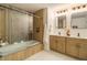 Well-lit bathroom featuring a glass shower and wood cabinets with quartz countertop at 14890 W 58Th Pl, Golden, CO 80403