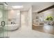 Bright primary bathroom featuring glass shower, modern tub, and direct access to primary bedroom at 14890 W 58Th Pl, Golden, CO 80403