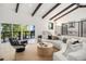 Cozy living area featuring vaulted ceilings, wooden beams, modern furnishings, and access to balcony at 14890 W 58Th Pl, Golden, CO 80403