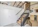 Open concept staircase with wooden stairs, black metal railing, and an accent stone wall at 14890 W 58Th Pl, Golden, CO 80403