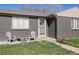 Inviting front entrance of home with gray brick, blooming flowers, and charming seating area at 373 S Locust St, Denver, CO 80224