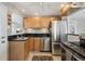 Bright kitchen featuring stainless steel appliances, wooden cabinets, and black countertops at 373 S Locust St, Denver, CO 80224