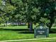 View of Crestmoor Park featuring green grass, trees, and park sign at 373 S Locust St, Denver, CO 80224