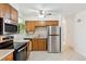 Cozy kitchen with stainless steel appliances, tile flooring, and wooden cabinets, offering functionality at 200 Perry St, Denver, CO 80219