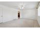 Bright living room with a ceiling fan, white walls and tiled flooring, leading into the kitchen at 200 Perry St, Denver, CO 80219