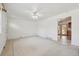 Open living room with neutral tiled flooring and a ceiling fan, offering views into the kitchen at 200 Perry St, Denver, CO 80219