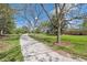 Scenic walking path with mature trees and lush green grass under a beautiful blue sky at 200 Perry St, Denver, CO 80219
