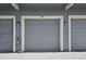 Attached garage doors with white trim on a well maintained townhome at 12115 Bannock St # B, Denver, CO 80234