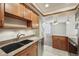 Well-lit kitchen featuring granite countertops, wood cabinets, tile flooring, and stainless steel appliances at 12115 Bannock St # B, Denver, CO 80234