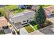 An aerial shot showcases a home with a carport, lush landscaping, and neighborhood views at 6103 Uno St, Arvada, CO 80003