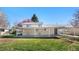 Spacious backyard with grass, mature trees, and a covered patio at 6103 Uno St, Arvada, CO 80003