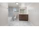 Bathroom with marble floors, a white marble tiled shower, a dark wood cabinet, and a neutral wall paint at 6103 Uno St, Arvada, CO 80003
