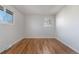 Well-lit bedroom featuring hardwood floors, neutral paint and two windows allowing for natural light at 6103 Uno St, Arvada, CO 80003