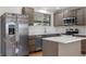 Updated kitchen features stainless steel appliances, island, and plenty of counter space at 6103 Uno St, Arvada, CO 80003