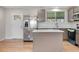 Renovated kitchen boasts stainless steel appliances, an island, and ample cabinet space at 6103 Uno St, Arvada, CO 80003