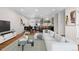 Staged living room features beautiful hardwood floors, a modern sofa, and dining area at 6103 Uno St, Arvada, CO 80003
