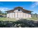 A large barn with a metal roof, painted light brown with a lawn in front of it at 2781 Savage Rd, Elizabeth, CO 80107