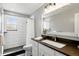 Updated bathroom features white subway tile shower, dark floors, and white vanity with dark countertop at 2781 Savage Rd, Elizabeth, CO 80107
