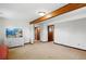Open-concept living space featuring a beamed ceiling, neutral paint, and easy access to other rooms in the home at 2781 Savage Rd, Elizabeth, CO 80107