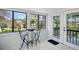 Bright sunroom with white paneling, tile floors, large windows, small table and two chairs overlooking backyard at 2781 Savage Rd, Elizabeth, CO 80107