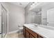 Bathroom featuring a single sink vanity, framed mirror, and tiled shower with a glass door at 14134 Glenayre Cir, Parker, CO 80134