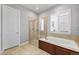 Bathroom with tiled shower, a tub, and window with shutter at 14134 Glenayre Cir, Parker, CO 80134