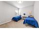Bright bedroom featuring two twin beds with blue comforters, side table, and neutral decor at 14134 Glenayre Cir, Parker, CO 80134