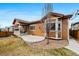 Landscaped backyard showcasing a covered patio and manicured lawn of this brown-sided home at 14134 Glenayre Cir, Parker, CO 80134