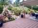 Landscaped backyard with a wooden deck, a tranquil waterfall feature, and beautiful garden accents at 276 Ember Pl, Castle Rock, CO 80104