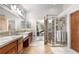 Elegant bathroom features a dual vanity, a glass shower enclosure, and tile flooring at 276 Ember Pl, Castle Rock, CO 80104