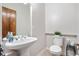 Powder room featuring a pedestal sink, decorative mirror, and modern fixtures at 276 Ember Pl, Castle Rock, CO 80104